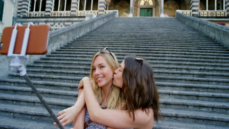 Two-happy-friends-taking-selfies-with-a-smartphone