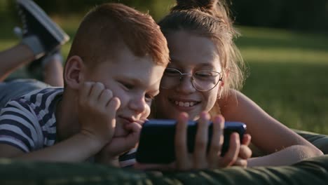 Video-of-smiling-children-spending-time-with-phone-on-vacation