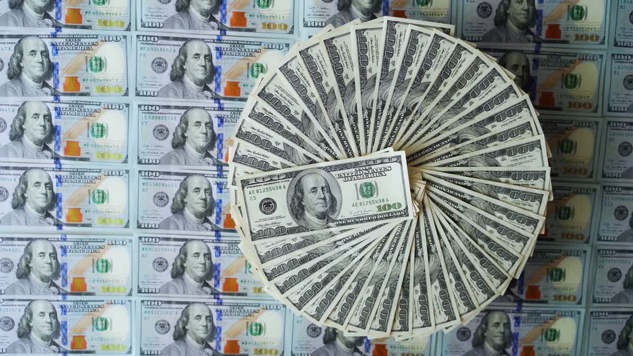 백 달러 지폐는 원형으로 되어 있으며, 백 달러의 미국 지폐의 재정적 배경은 잘 배치된 현금, 종이, 돈이 회전하고 있다.