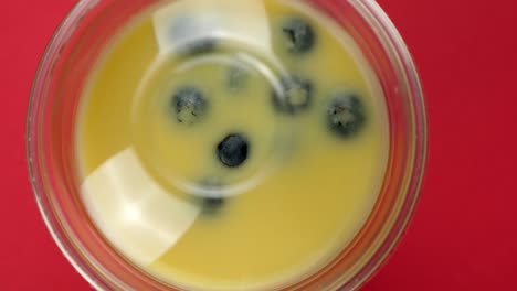 top down close up of a smoothie rotating on a red backdrop