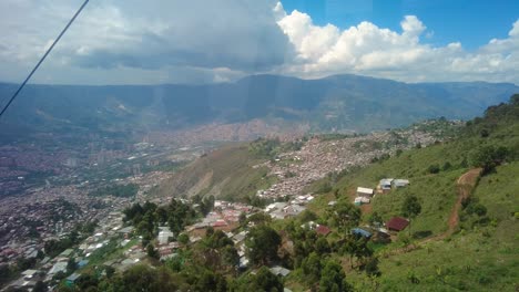 A-stunning-panoramic-view-of-Medellin-shows-the-colorful-cityscape-in-all-its-glory,-surrounded-by-lush-green-mountains