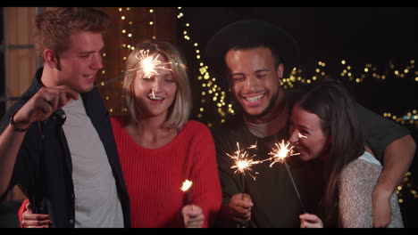 group of friends lighting sparklers at outdoor party