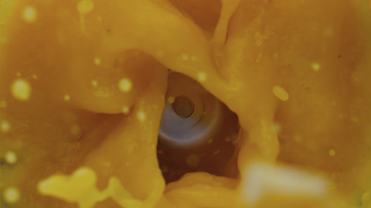 블렌더에서 오렌지 과일 스무디를 만드는  뷰 시트러스 떨어지는 혼합물