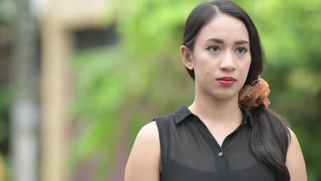 young beautiful asian businesswoman thinking in the streets outdoors