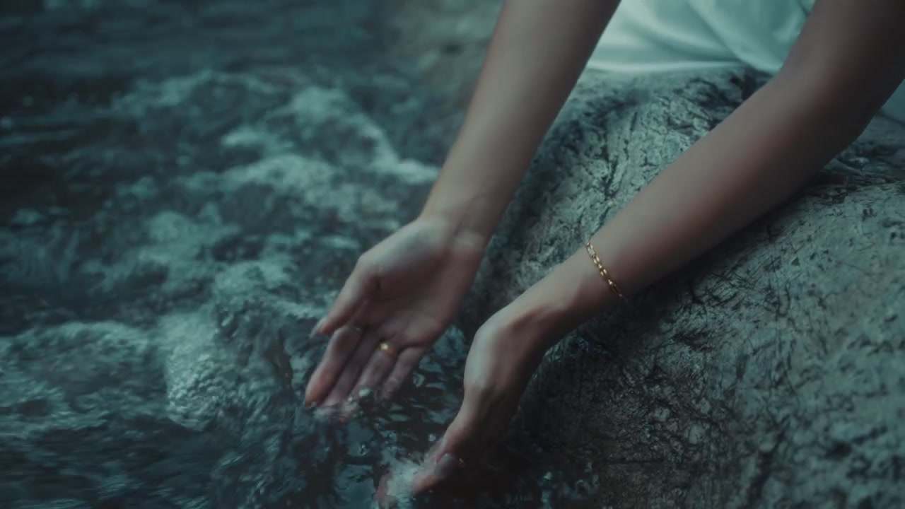 Donna che tocca l'acqua corrente del fiume con le mani