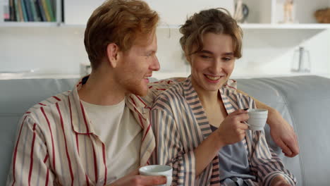 Joyful-lovers-watching-laptop-on-comfy-couch-closeup.-Romantic-couple-in-morning