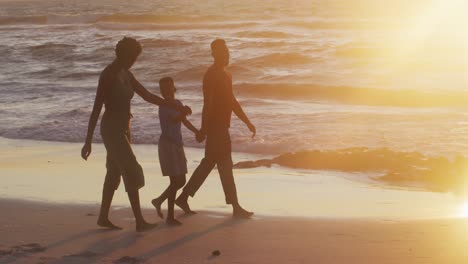 Video-Einer-Glücklichen-Afroamerikanischen-Familie,-Die-Bei-Sonnenuntergang-Am-Strand-Spaziert