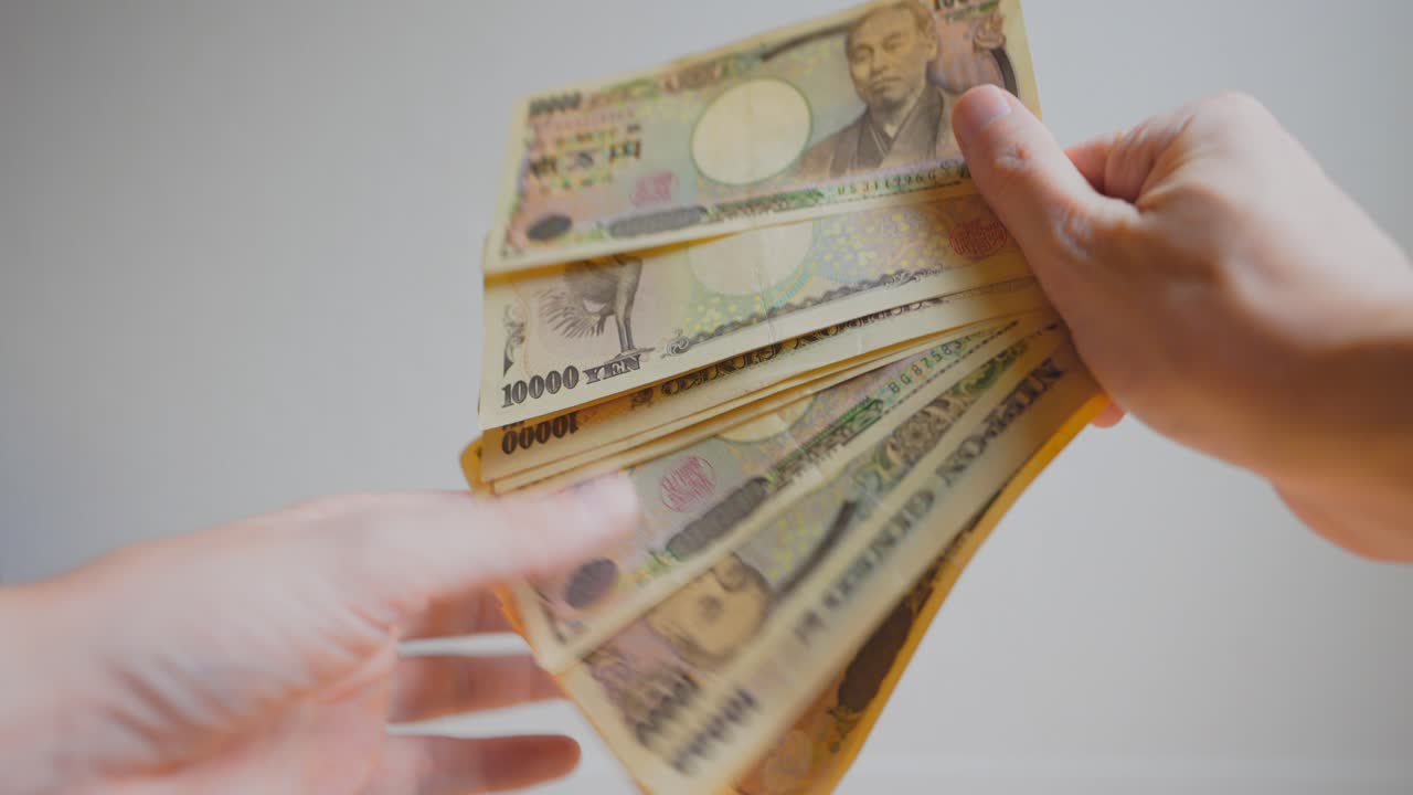 誰かの手が日本円を持っているショット