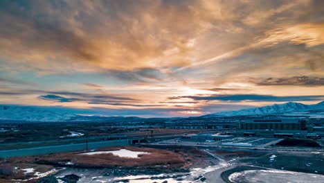 una puesta de sol dorada con montañas nevadas y una carretera del valle - hiperlapso aéreo