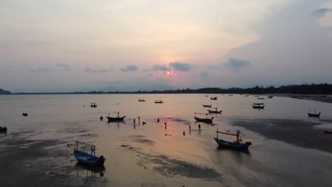 Aéreo:-La-Gente-En-Marea-Baja-Prepara-Barcos-Para-Ir-Al-Mar-Al-Atardecer