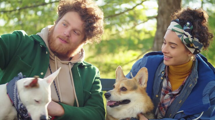 Coppia felice e i loro cani che si scattano un selfie in un parco
