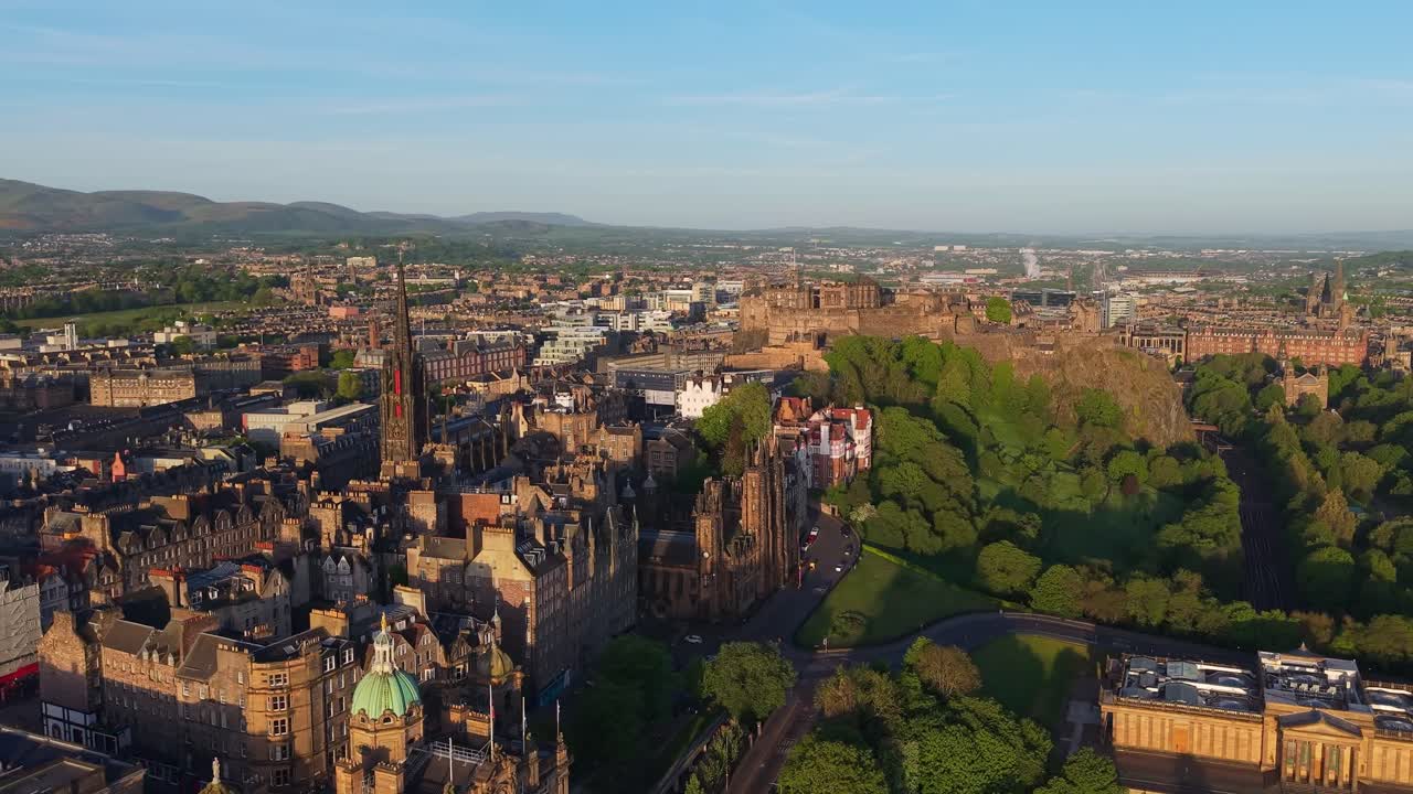 Imagens aéreas de Edimburgo ao nascer do sol enquanto a cidade desperta sob uma suave luz dourada, revelando telhados, marcos e ruas tranquilas