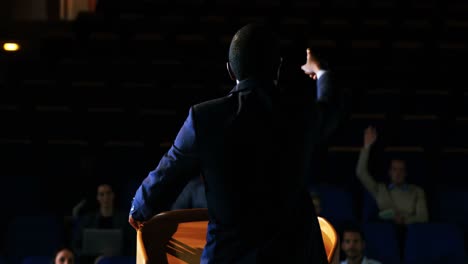 rear view of male business executive giving a speech