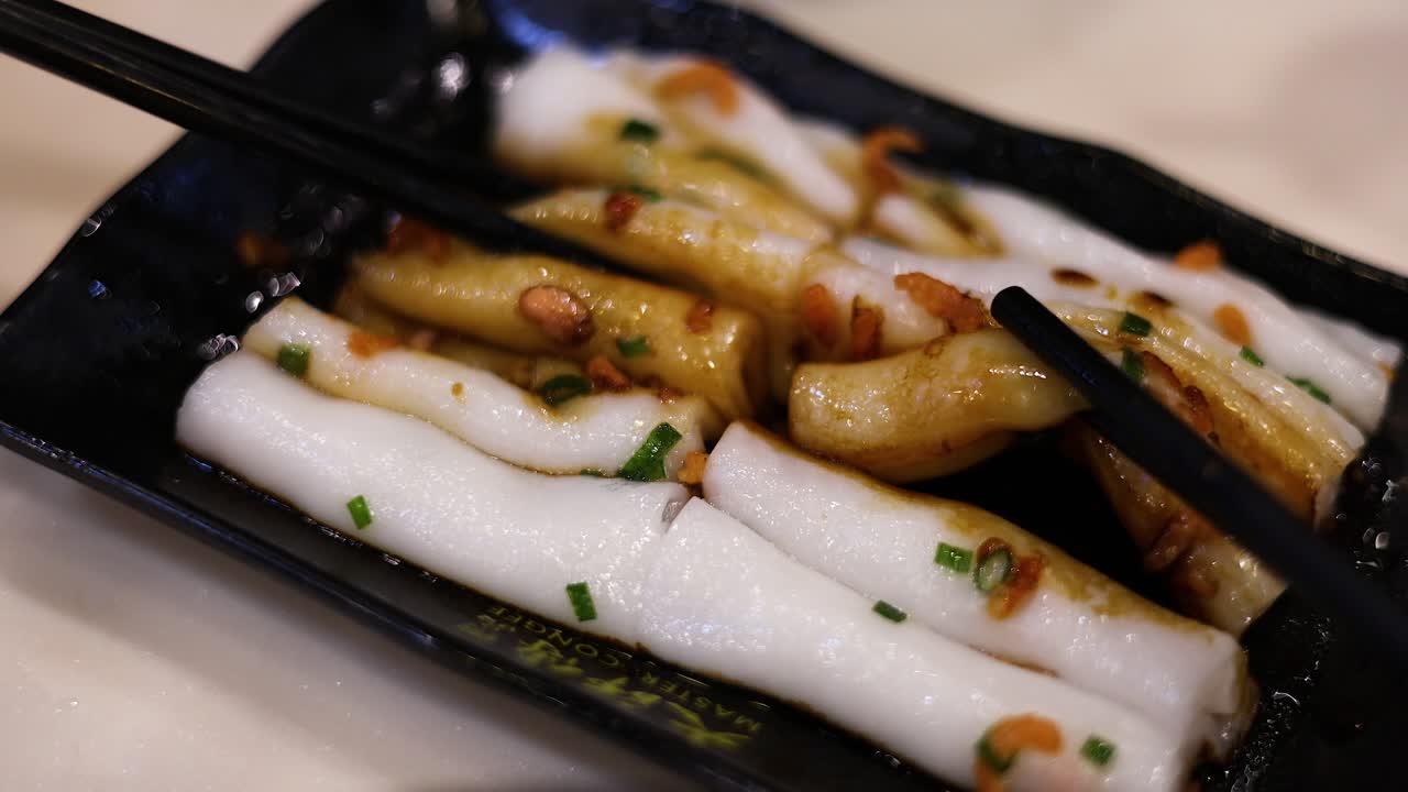 palillos para comer recogiendo rollos de fideos de arroz