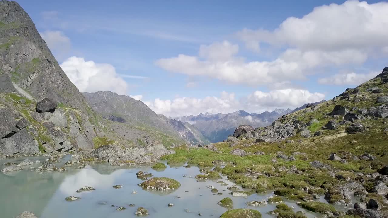 Drone shot of Alaska's Hatcher Pass in the summer with freshwater and clouds