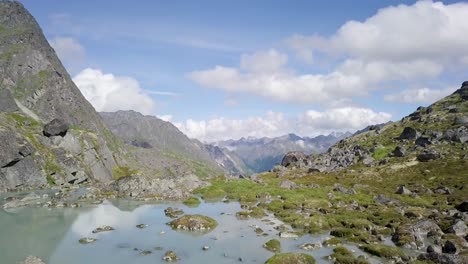 Drone-shot-of-Alaska's-Hatcher-Pass-in-the-summer-with-freshwater-and-clouds