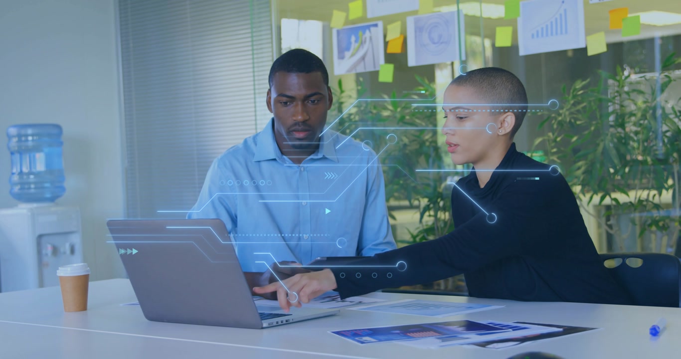 Project cue driving coworkers, woman guiding laptop demo while man checking tablet to update charts