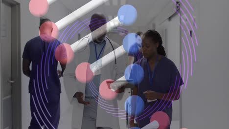 Animation-of-dna-strand-over-african-american-female-and-male-doctor-with-tablet-talking-in-hospital