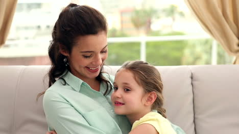 madre y hija felices en el sofá