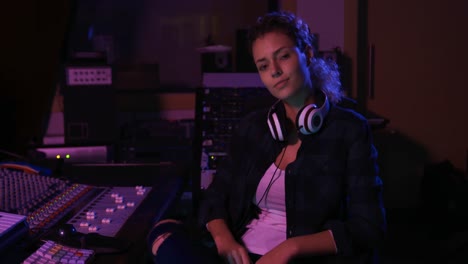 ingeniera de sonido sentada en un escritorio de mezcla