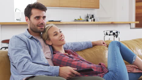 Pareja-Sentada-En-El-Sofá-Viendo-La-Televisión-Juntos