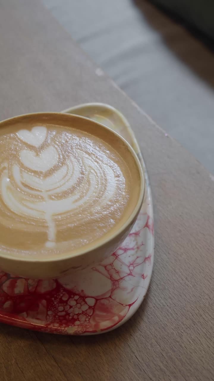 Primo piano di un latte con splendida latte art su un tavolo di legno