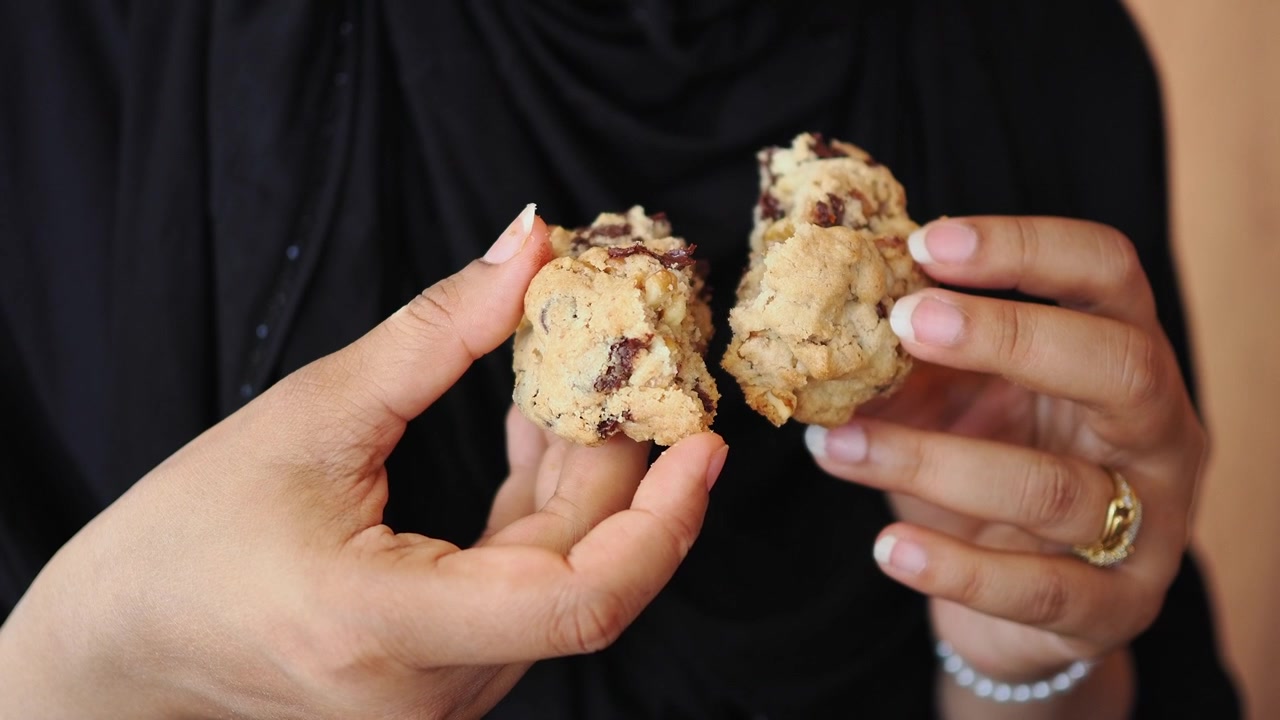 Person Holding a Broken Chocolate Chip Cookie