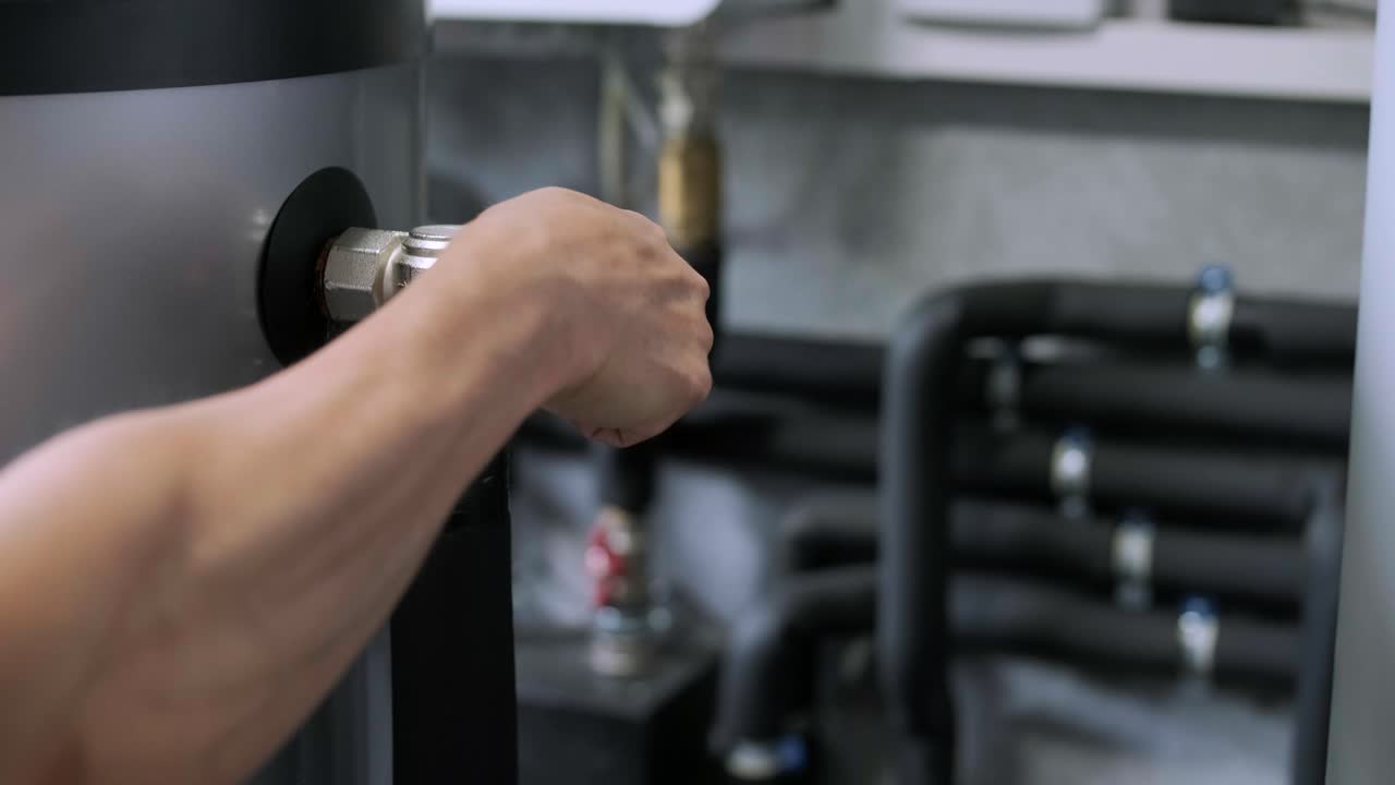 un hombre está instalando el sistema de calefacción en la casa. interior de la sala de calderas de la casa con sistema moderno de calentamiento de agua