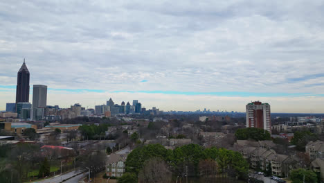 Toma-Aérea-Inclinada-Hacia-Arriba-Del-Suburbio-De-La-Ciudad-De-Atlanta-Con-Horizonte-En-El-Centro-De-La-Ciudad-En-Un-Día-Nublado