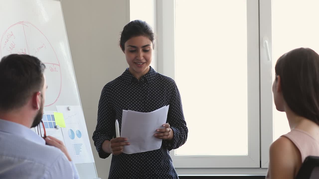 Indian businesswoman makes speech, presenting report to colleagues during meeting