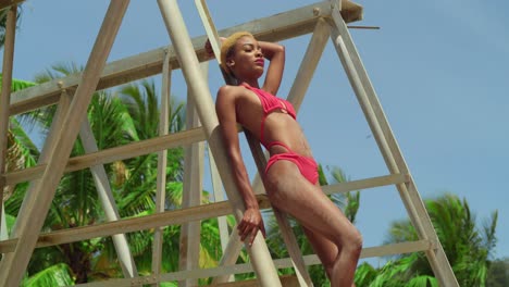 A-black-girl-showcases-her-style-in-a-red-bikini-while-relishing-a-tropical-day-on-a-Caribbean-beach