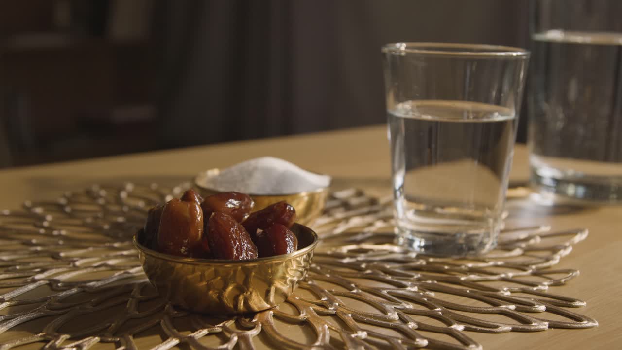 eid 3을 축하하는 이슬람 가정의 테이블 위에 물 한 잔이 있는 날짜 그릇