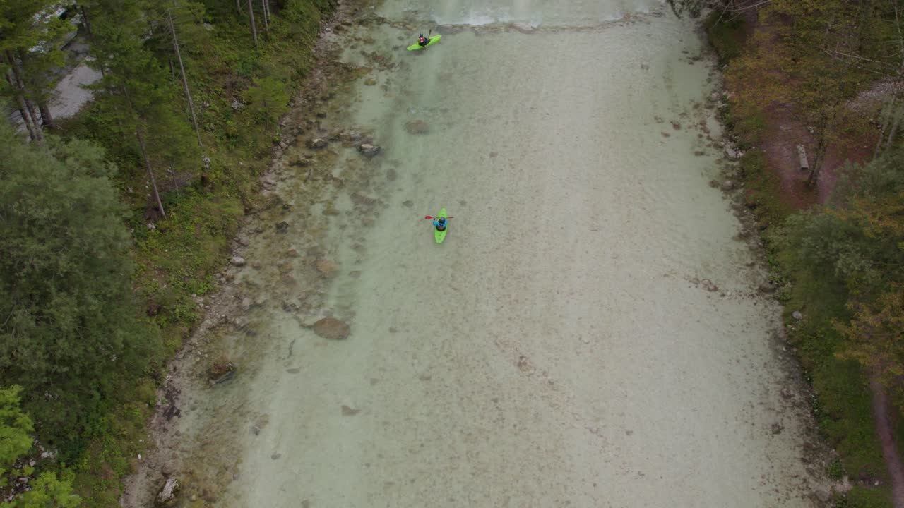 Group of green kayaks paddling in the Soca river during day time, aerial