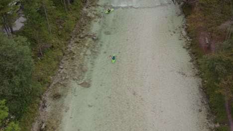 Group-of-green-kayaks-paddling-in-the-Soca-river-during-day-time,-aerial