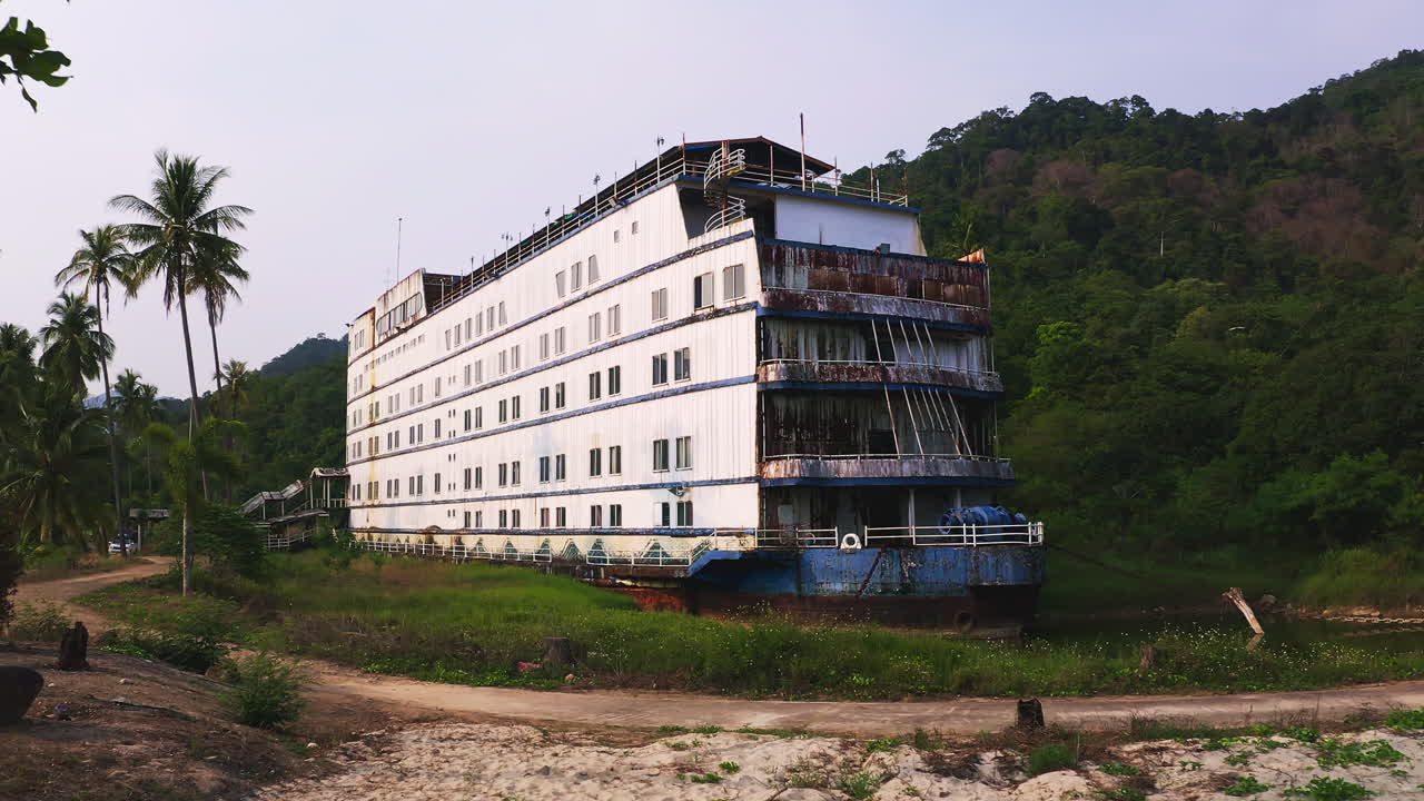 Bataklık ve bitki örtüsüyle kaplı plaj lagününde, Koh Chang'ın terk edilmiş hayalet gemisi.