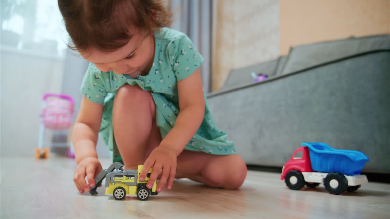 A Young Child Engages in Creative Play with Colorful Toy Trucks, Fostering Imagination and Motor Skills in Their Home Environment
