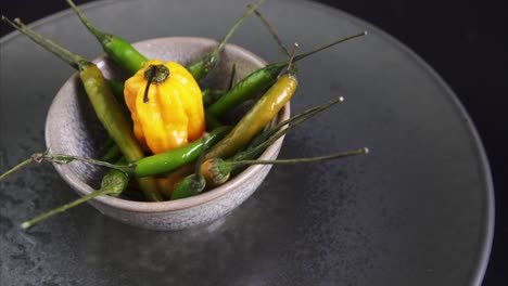 close up of rotating chili peppers with a fresh carolina reaper in the middle