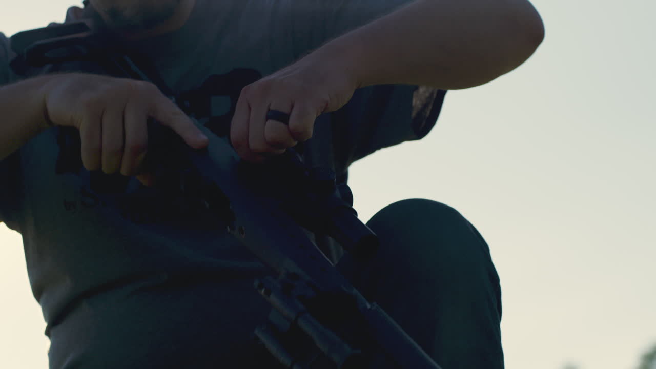 Man Checks Clip And Chamber Of Semi-Automatic Rifle In Preparation To Shoot