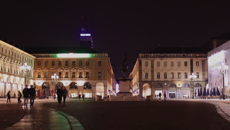 wide shot of italian city square at night illuminated by colour lights