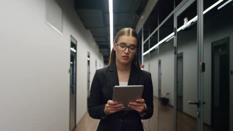 sad professional using tablet reading email. upset employee walk office corridor