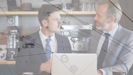 animación de redes de conexiones sobre dos empresarios caucásicos usando una computadora portátil