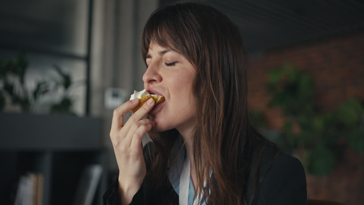 A businesswoman enjoys a cupcake