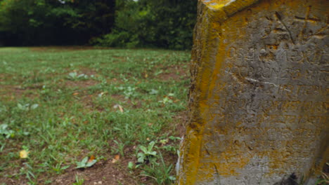 A-cinematic-panning-view-of-a-tombstone-of-an-old-Christian-grave-in-the-graveyard