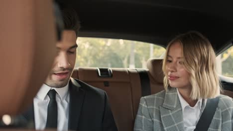 una pareja de negocios sonriente y confiada discutiendo algo.