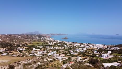 Cinematic-drone-shot-approaching-city-by-the-sea-during-sunny-day