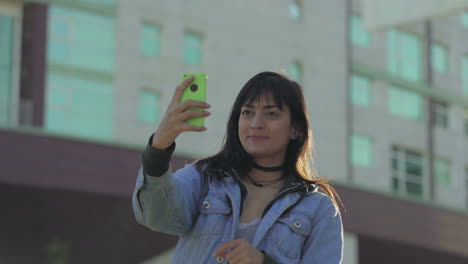 una adolescente alegre tomando una selfie con su teléfono inteligente.