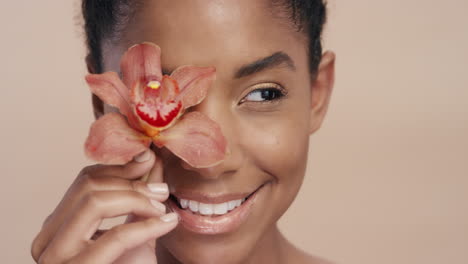 beauty portrait beautiful african american woman playfully posing with orchid flower touching healthy skin complexion enjoying gentle fragrance of natural essence skincare concept