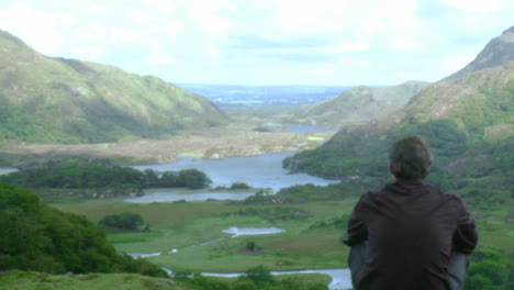 young man relaxing on the top of a mountain