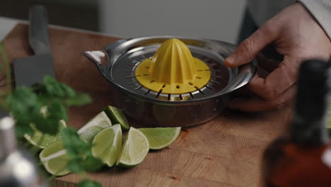 Young-male-placing-a-lemon-press-on-the-kitchen-worktop