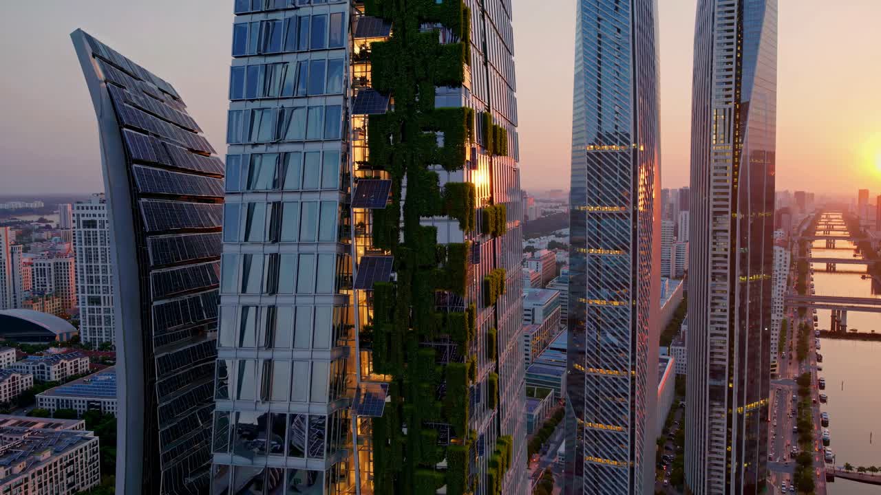 Aerial view of futuristic skyscrapers with greenery at sunset, showcasing urban innovation